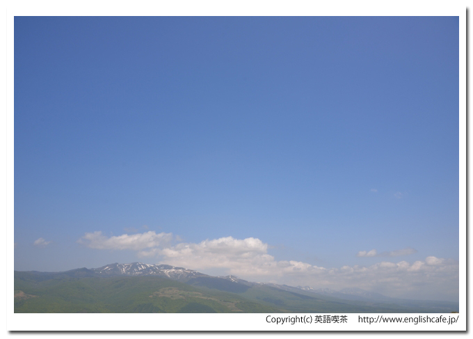磯谷高原、頂上から、谷を挟んで向こう側に広がる山々と青空の景色（北海道寿都郡寿都町）