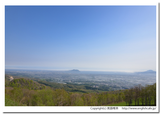 城岱牧場、眼下に広がる街、青い空と函館山（北海道七飯町）